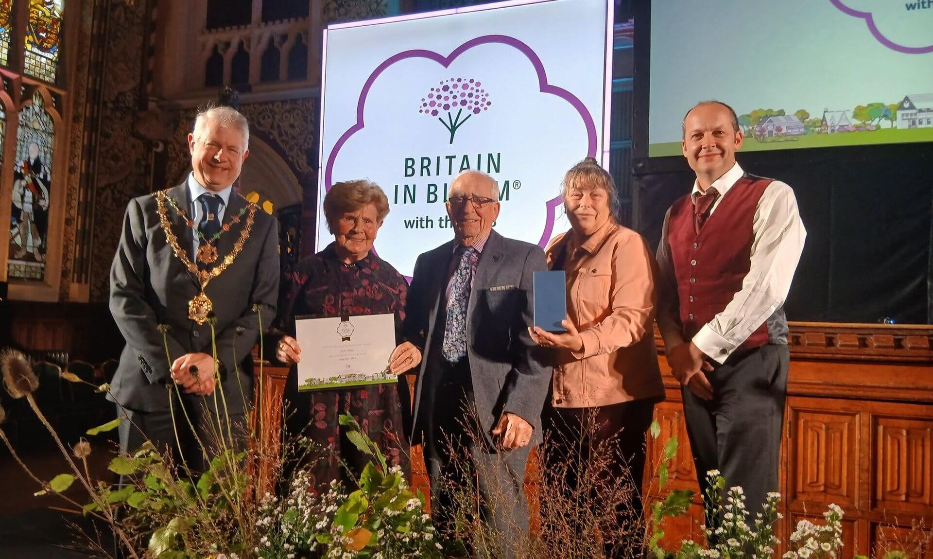 Truro's representatives on stage at the Britain in Bloom 2026 awards holding a certificate and medal