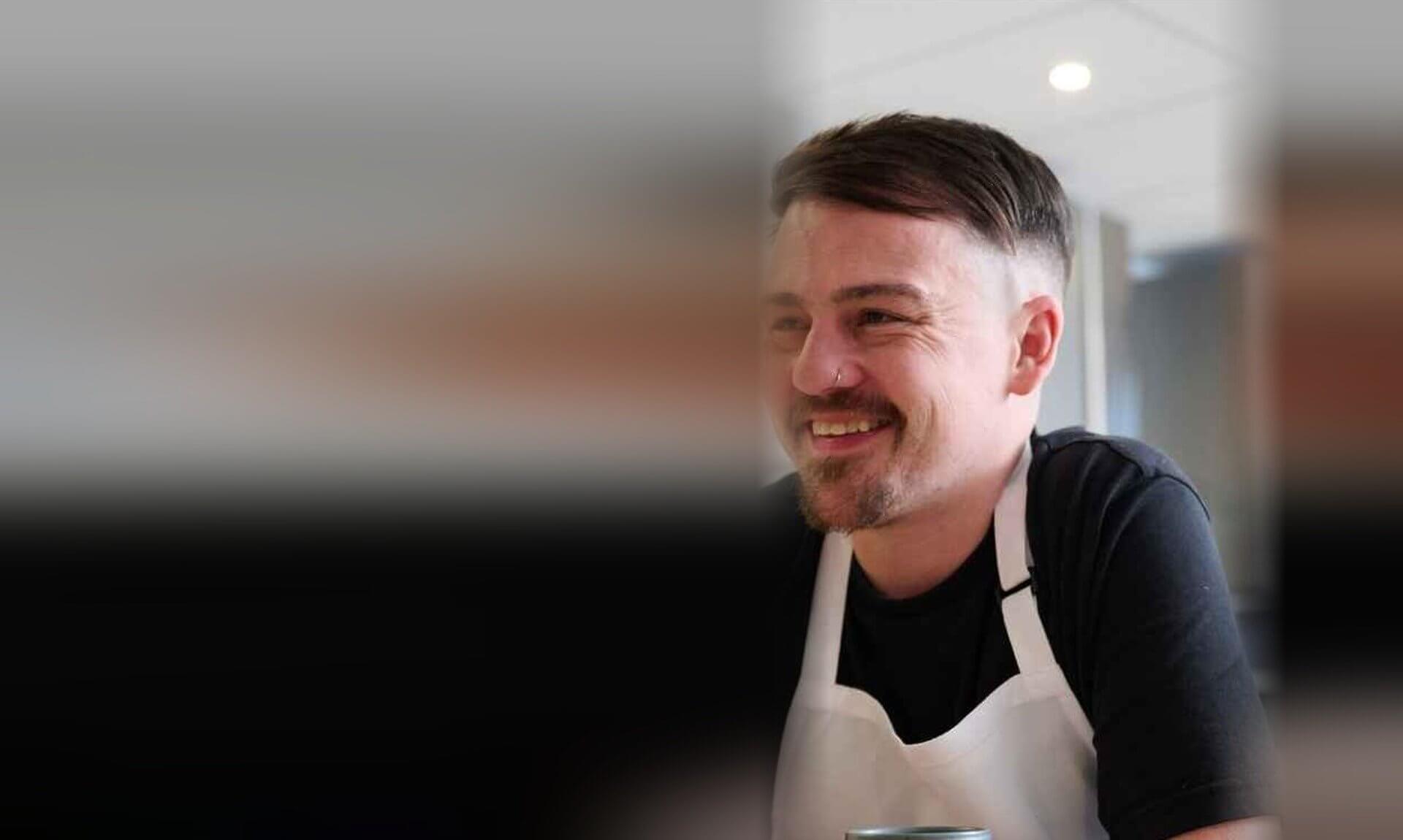 Chris, a YMCA Cornwall resident, smiling in a kitchen