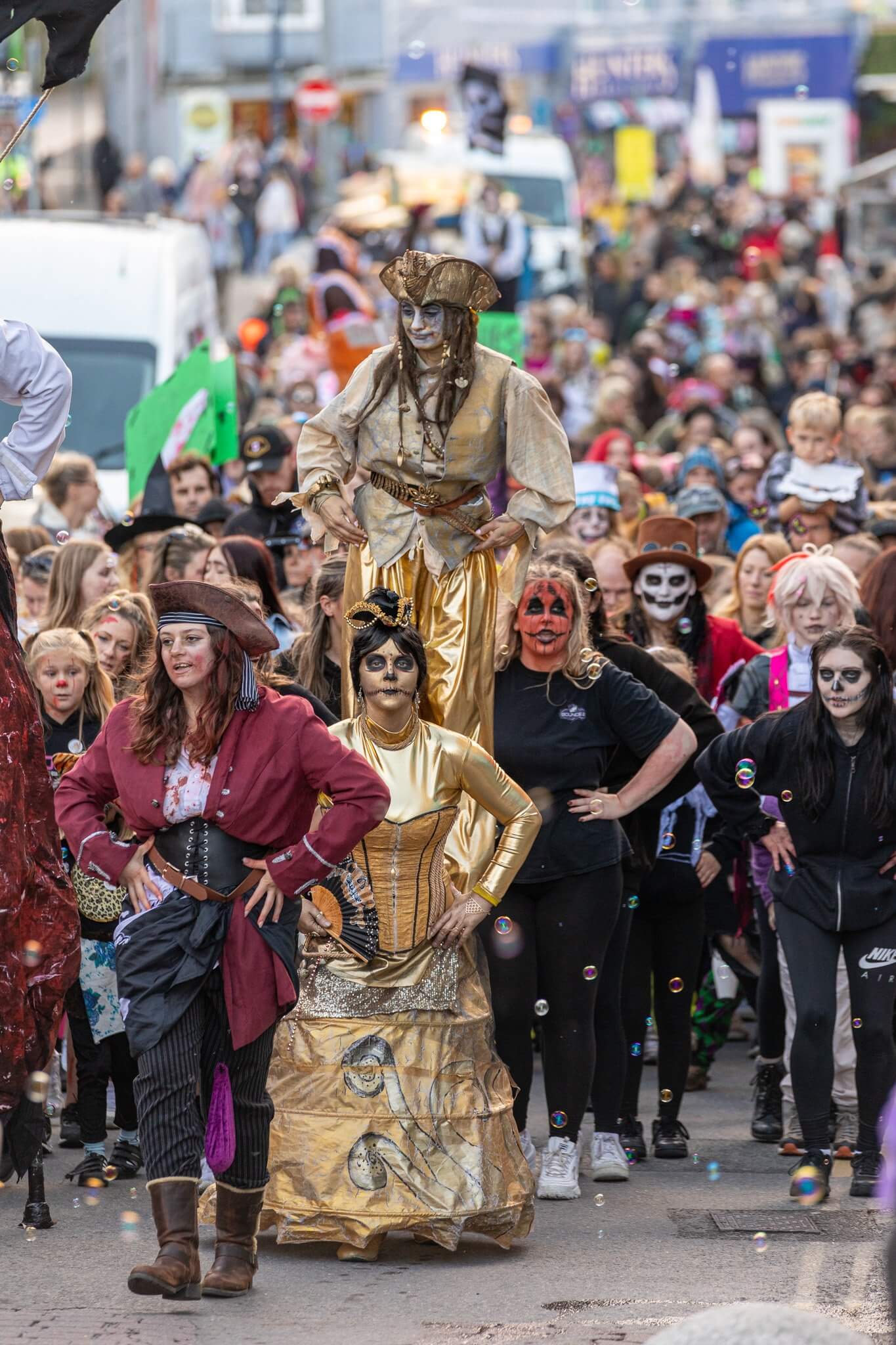 Crowds of zombies, pirates and a gold stilt walker filling a Newquay street during the Zombie Crawl